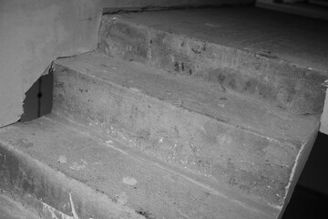 Concrete stairs lead to an unfinished basement in a residential building