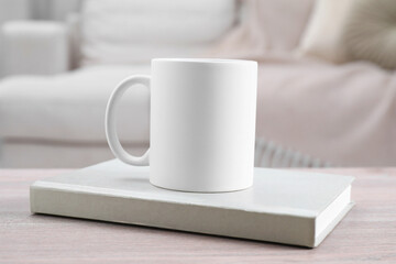 Blank ceramic mug and notebook on wooden table. Mockup for design