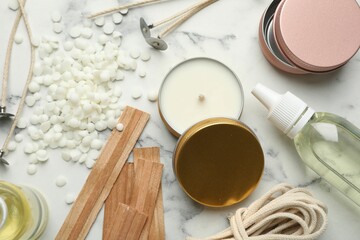 Soy wax and other supplies for making candles on white marble table, flat lay