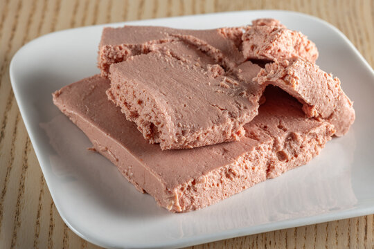 Pink, smooth, spreadable pork liver p&acirc;t&eacute; on a plate.