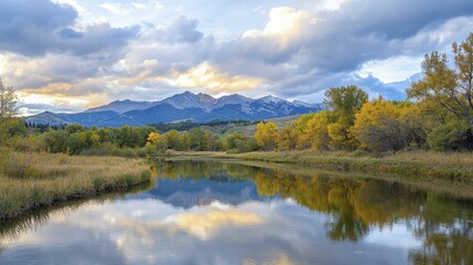 Stunning mountain range at sunrise with dramatic clouds, showcasing vibrant colors and serene reflections in a tranquil lake.