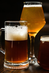 Variety of beer glasses with different types of beer on wooden table. Close-up.