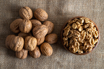 Peel walnuts and whole walnuts in wooden bowl,top view 