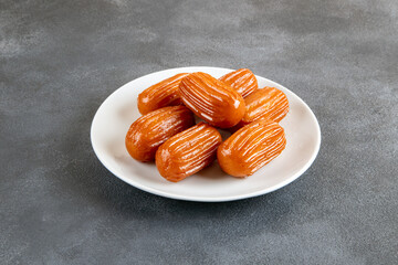 Traditional Turkish dessert tulumba on a plate. Tulumba dessert, fried in oil and soaked in syrup
