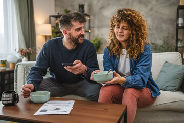 couple eat oatmeal and making a contactless payment using smart phone