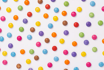 Brightly coloured sweets on white background. Rainbow colored candy. Happiness and cheerfulness concept