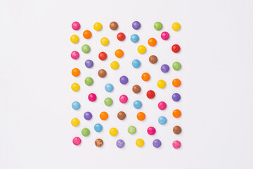 Brightly coloured sweets on white background. Rainbow colored candy. Happiness and cheerfulness concept