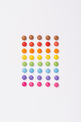 Brightly coloured sweets on white background. Rainbow colored candy. Happiness and cheerfulness concept