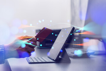 Online shopping via the internet. A guy holding a bank credit card with a tablet with abstract network effects on a table.