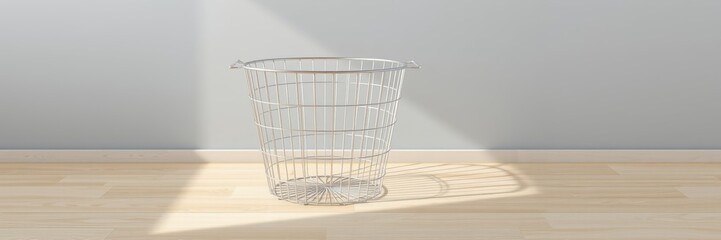 Empty wire basket with a minimalistic vibe casting a shadow on wooden floor
