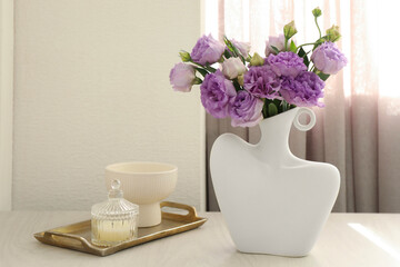 Stylish vase with beautiful flowers and decor on white wooden table at home