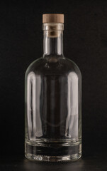 750ml clear Nordic glass bottle with a wooden cork stopper, standing against a black background. Ideal for storing liquids, oils, or homemade beverages. Elegant and minimalist design.