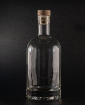 750ml clear Nordic glass bottle with a wooden cork stopper, standing against a black background. Ideal for storing liquids, oils, or homemade beverages. Elegant and minimalist design.