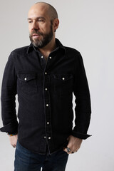 Vertical headshot of smiling mature man looking away posing indoor. Mindset concept.