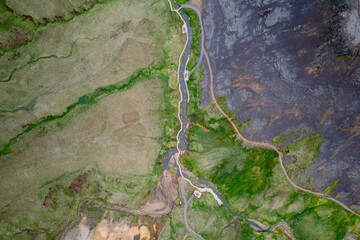 Drone aerial view of Reykjadalur Hot Spring Thermal River with scenic valley with stream and rugged...