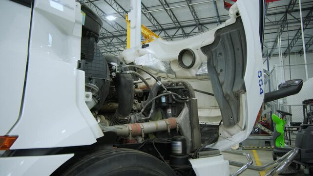 Truck in repair shop with open hood, Various devices and semi truck in a repair shop