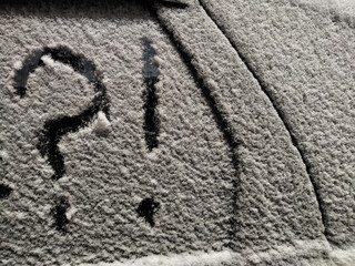 Frosted vehicle displays a question mark with an exclamation point amid uncertainty in a winter landscape