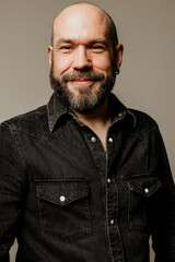 Obraz premium Headshot of smiling bearded mature man looking away posing indoor. Mindset concept.