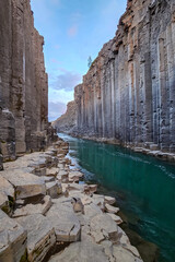 Aerail view of scenic basalt Studlagil Canyon with clear Jokulsa a Dal river and unique columnar basalt formations in the middle of white night in June in Iceland