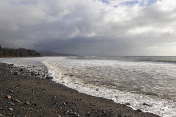 Waves breaking on a rocky beach on a cloudy winter day