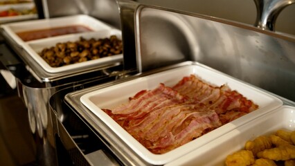 Delicious crispy bacon and chicken nuggets served on white ceramic trays