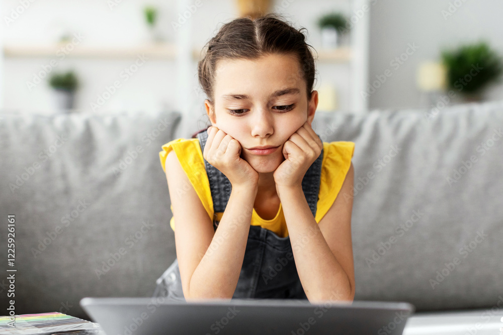 Aufkleber boredom concept. sad young girl sitting at desk using laptop at home, looking at computer screen. ti