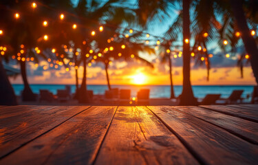 A beach scene with a wooden table and chairs. The table is lit up with lights and the sun is setting in the background