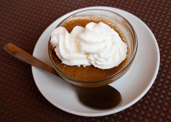 Baked sweet dessert coffee mousse made from fermented milk product, gently creamy color and lush texture. Dessert is decorated with flowers made of whipped cream