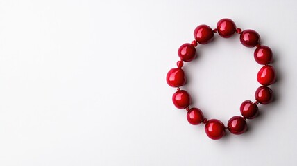 Obraz premium Red beaded bracelet arranged in circle on white background