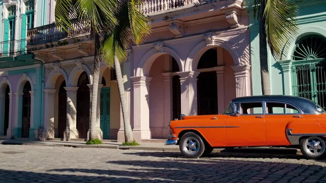 Classic orange car parked on a cobblestone street in front of colorful colonial architecture in Havana, Cuba, adding a vibrant touch to the historical setting