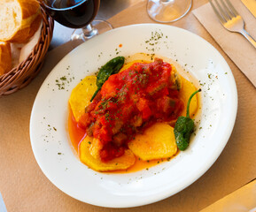 Popular spanish dish cod with sanfaina, sauteed vegetables and tomato sauce