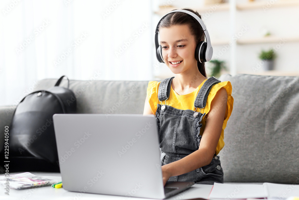 Poster E-learning concept. Smiling teenager in headset studying online on laptop computer at home. Happy youth using PC to make home assignment, typing on keyboard, chatting with friends or doing homework