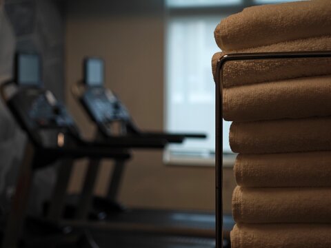 Modern fitness center offers an inviting atmosphere with neatly stacked towels and state-of-the-art equipment ready for an energizing workout session