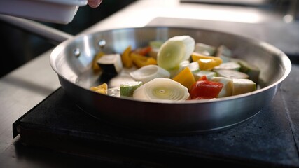Chef saute ing vegetables in a pan