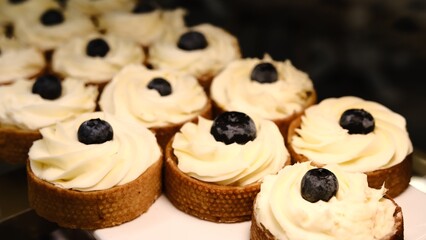 beautiful white cheesecake tart with fresh blueberries in shortcrust pastry basket placed on a white plate on the counter perfect dessert for a bakery or cafe sweet indulgence for food photography