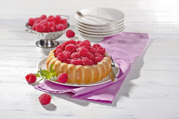 Tarta malinowa ze świeżymi malinami na stole © Jolaya