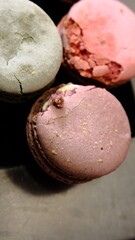 Damaged colorful macarons in close-up showing imperfections and cracks caused by poor transportation highlighting delicate texture of the dessert and the impact of improper handling on fragile treats