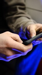 Young man playing mobile game with fast finger movements and colorful pulsating hand lights, dynamic gameplay, close up phone screen, digital entertainment, gaming action, energetic gaming session.