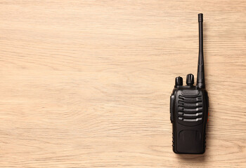 One walkie talkie on wooden table, top view. Space for text