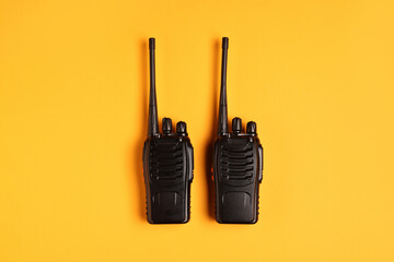 Walkie talkies on orange background, top view