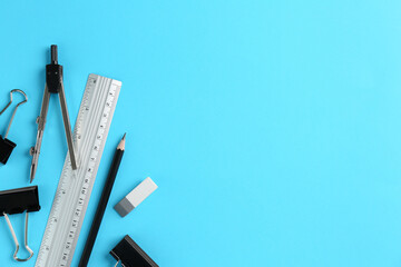 Flat lay composition with ruler and other stationery on light blue background, space for text