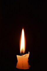 Burning candle on black background