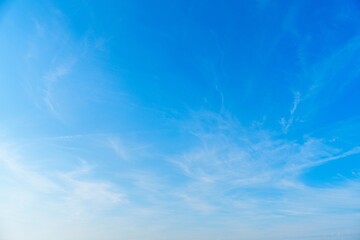 Delicate feathery cirrus clouds drift across the expanse of the sky, creating a serene and tranquil...