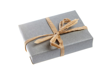 Small rectangular gift wrapped in biodegradable gray paper and tied with a rustic natural fiber bow. A sustainable and plastic-free packaging option on a white background