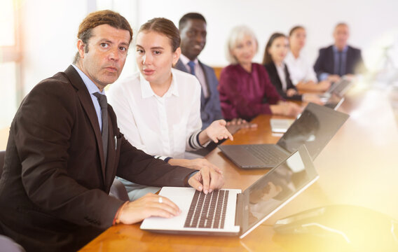 Young woman secretary chatting with her boss during meeting in conference room.