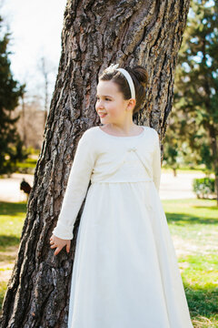 Girl in First Communion Dress with Headband in Nature