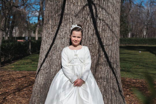 Young Girl in First Communion Dress Posing Outdoors