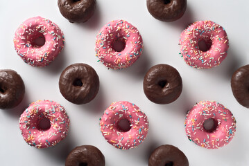 Top view of strawberry and chocolate donuts with sprinkles