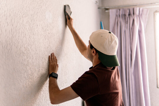 Man applying plaster on wall during home remodeling