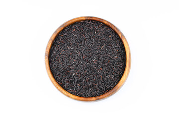 pile of black rice in a wooden bowl isolated on a white background.